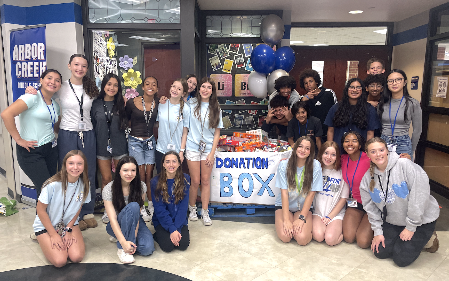 Arbor Creek Middle School students pose with their donations to CCA's Food Pantry. October 2024